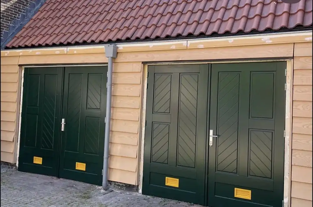 Twee sets groene houten openslaande garagedeuren