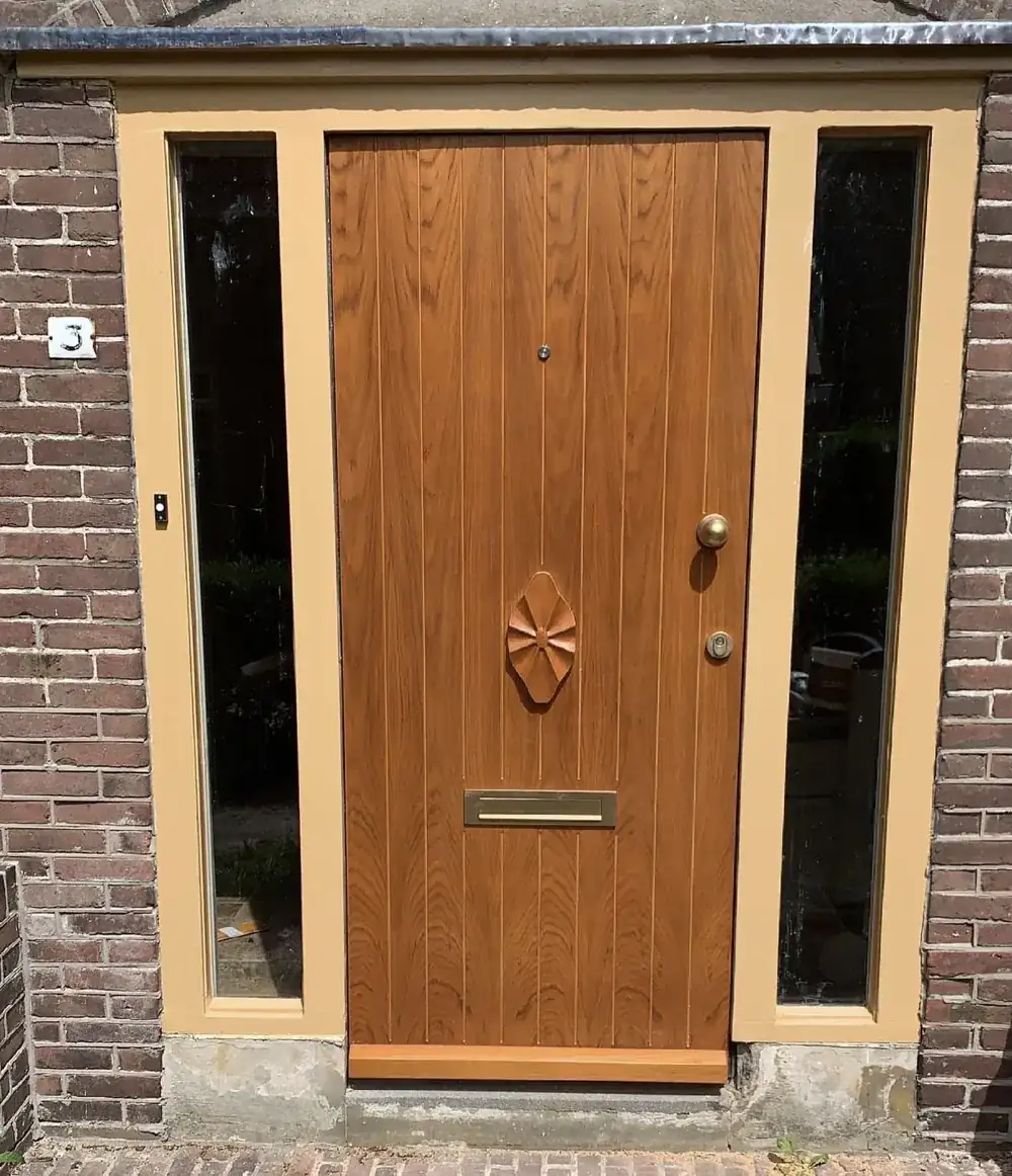Houten voordeur met zijlichten in een gemetselde gevel
